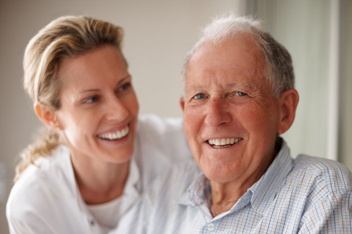 senior man smiling with care giver