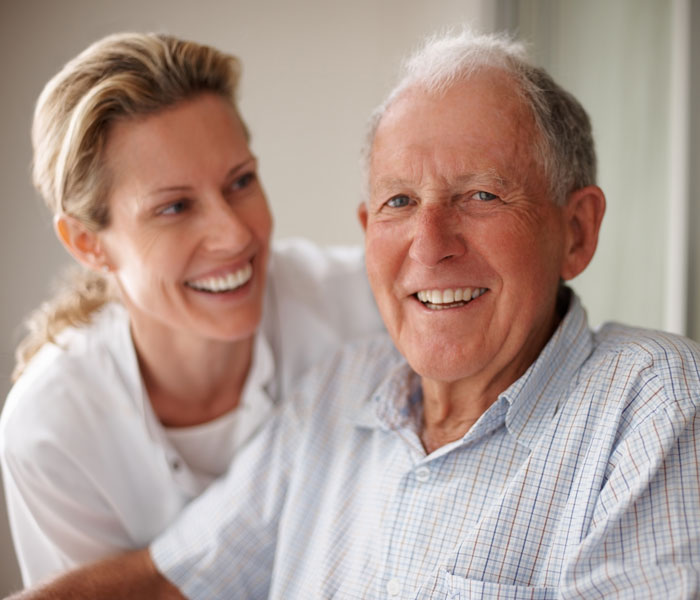 senior man smiling with care giver